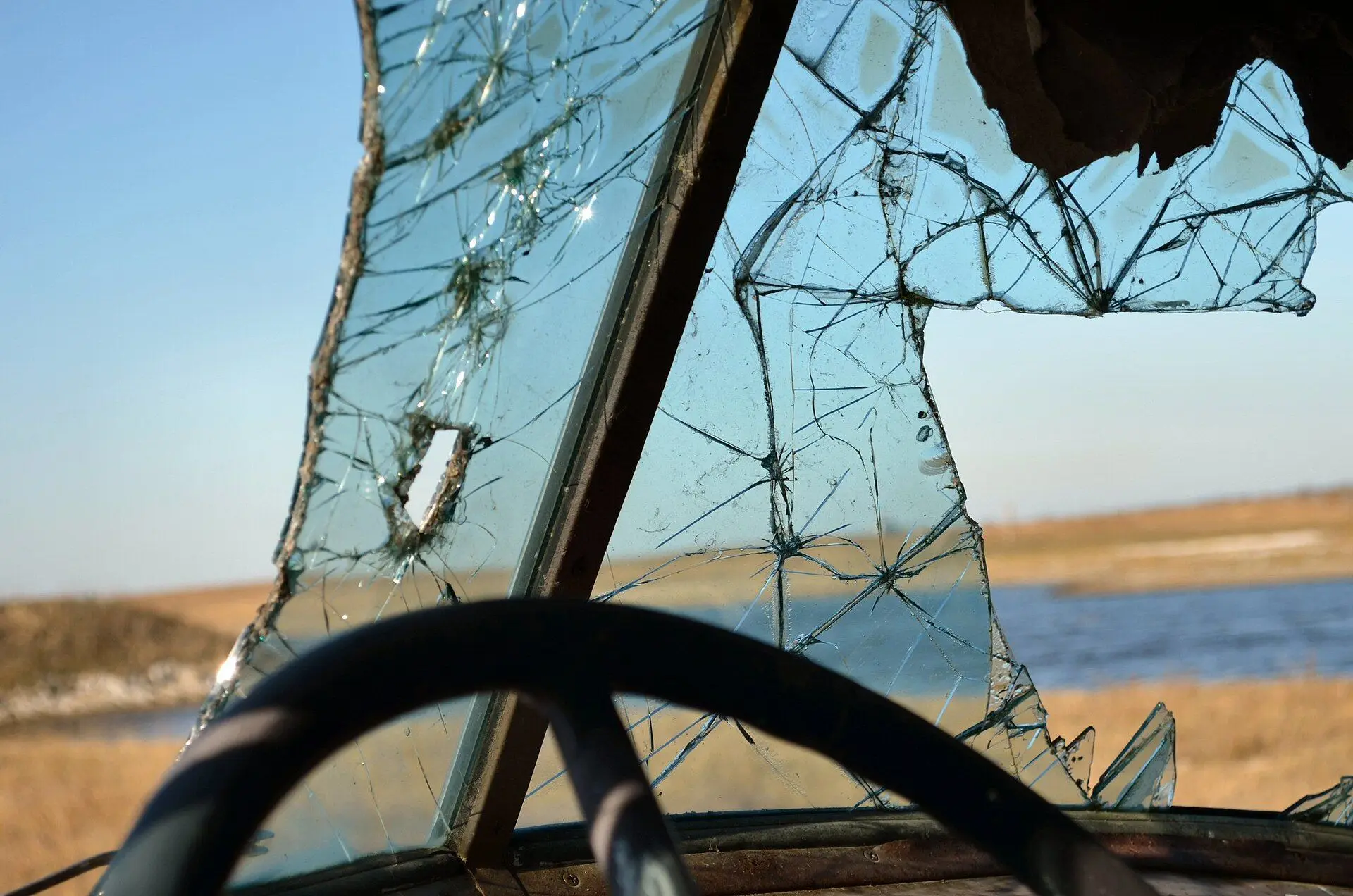 View through a broken windshield of an abandoned vehicle